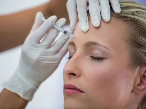 Provider administering a Botox injection to a patient's forehead