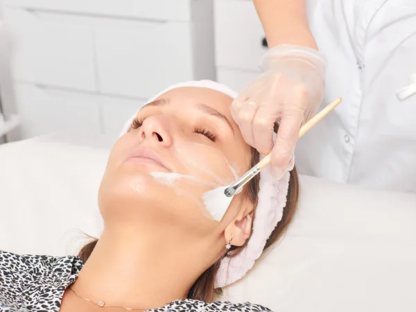 Provider applying a chemical peel solution to a patient's face