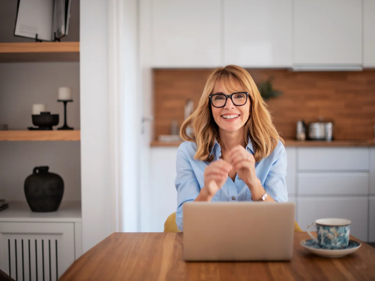 Woman at her laptop at home enquiring about a cosmetic dermatology appointment