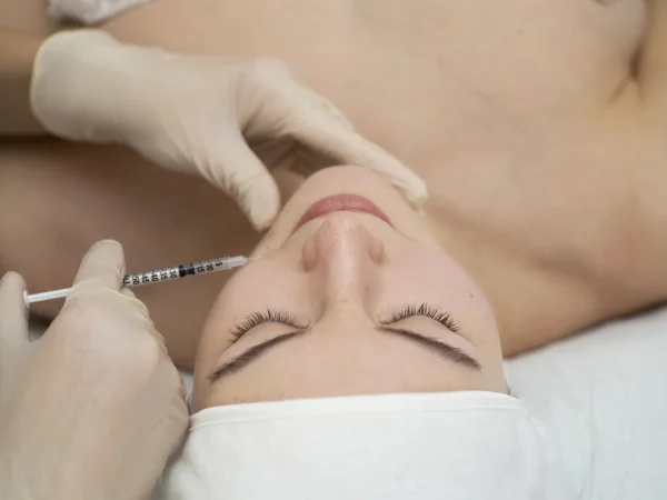Provider performing a dermal filler injection around a patient's mouth