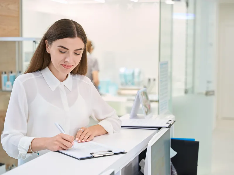 Patient completing insurance paperwork at the reception desk
