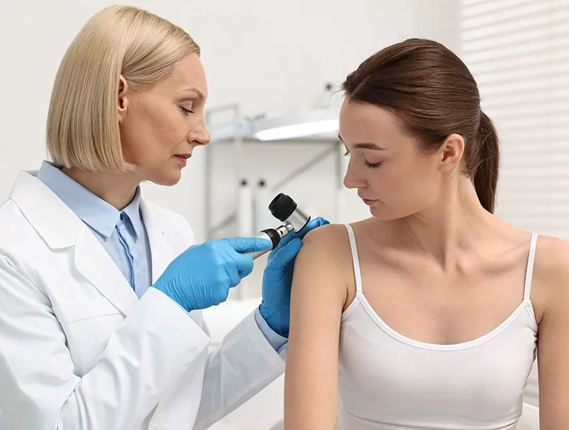 Dermatologist examining a patient's skin during a medical dermatology visit