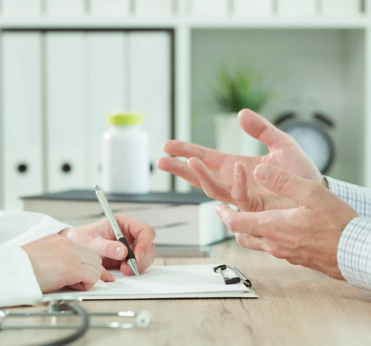 Patient describing a persistent rash to a dermatologist during an appointment