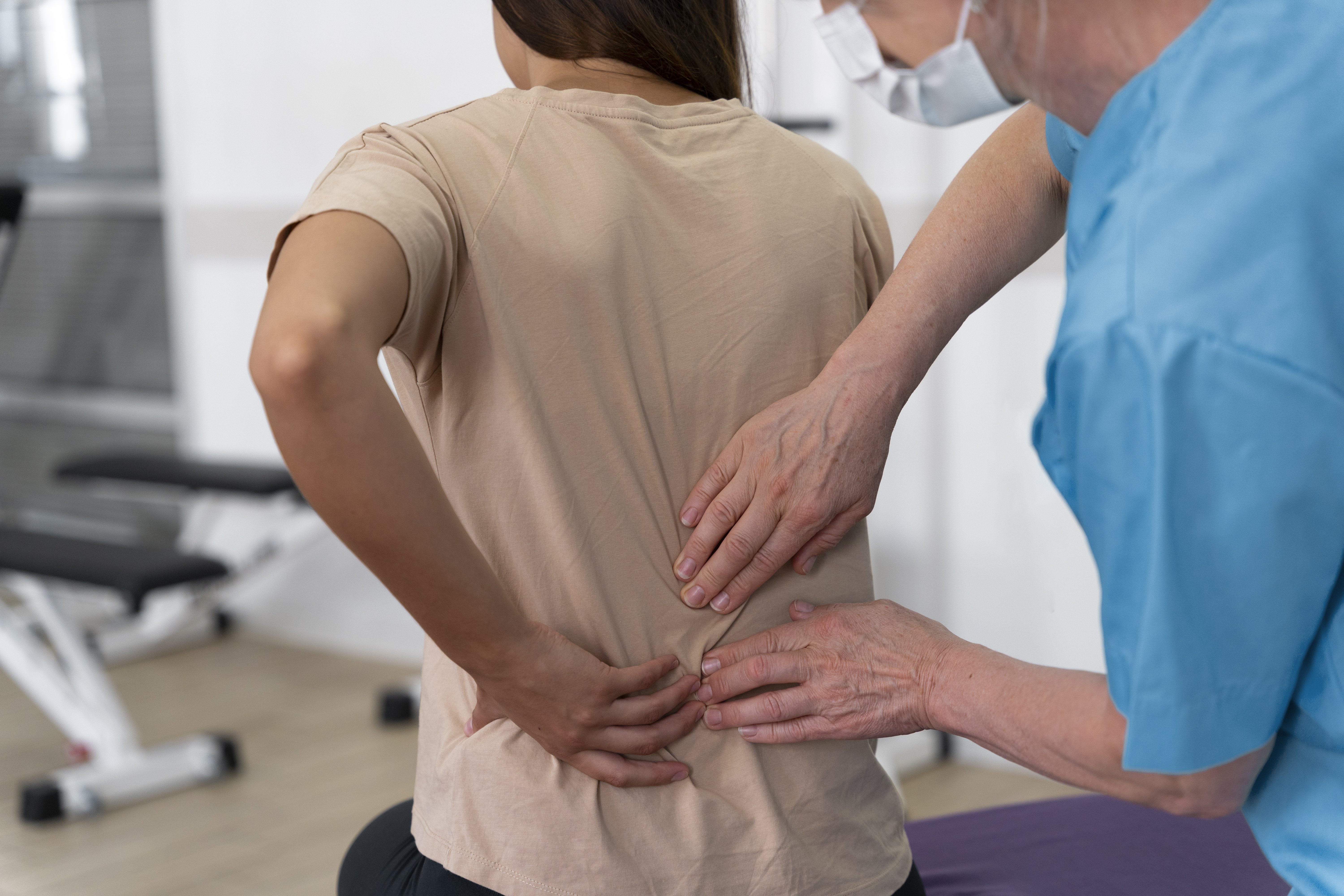Lumbar Radiculopathy (Sciatica) Treatment in Coppell, TX Pain specialist evaluating a patient's lower back pain during lumbar radiculopathy (sciatica) treatment in Coppell, TX.
