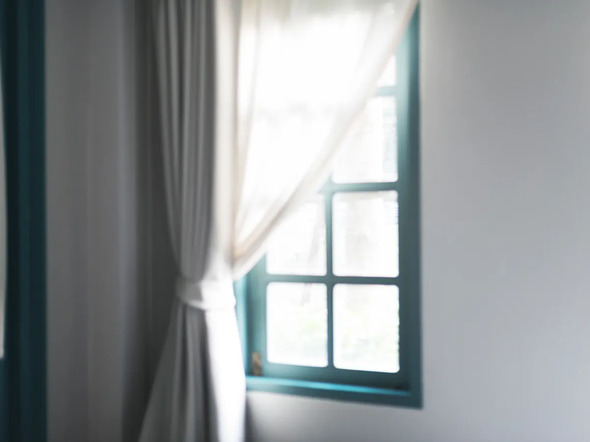 Soft daylight through a curtained window in a quiet room.