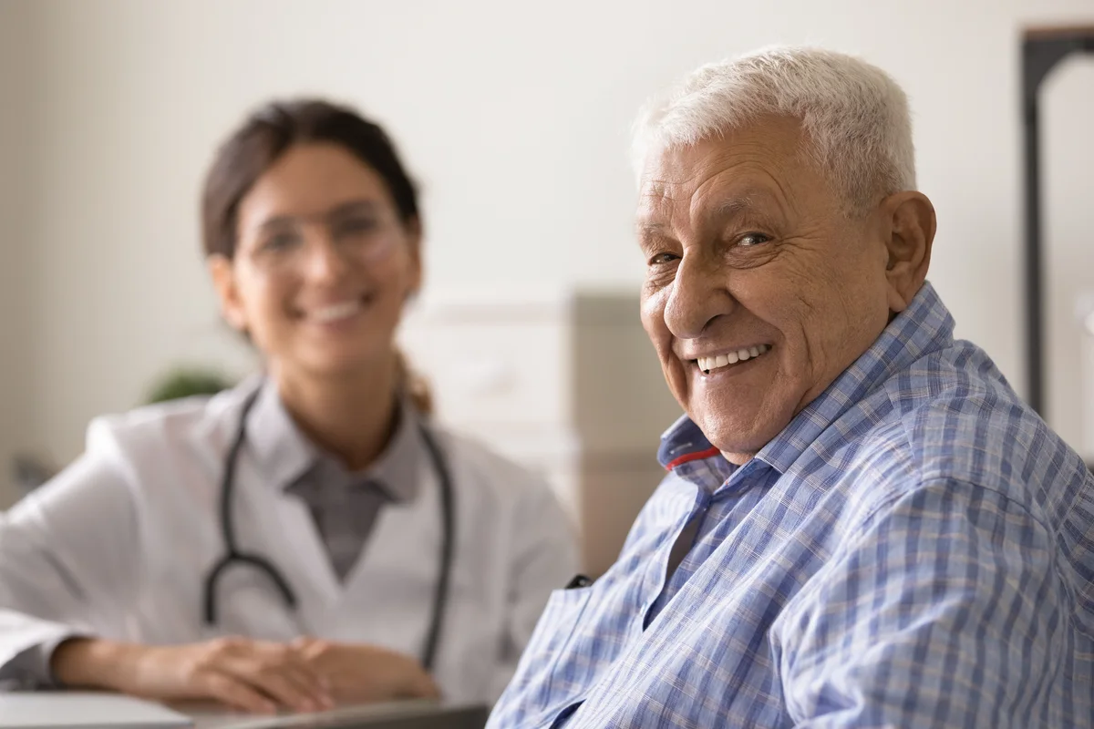 Spanish-speaking physician smiling with an older Hispanic patient at an Anaheim primary care visit