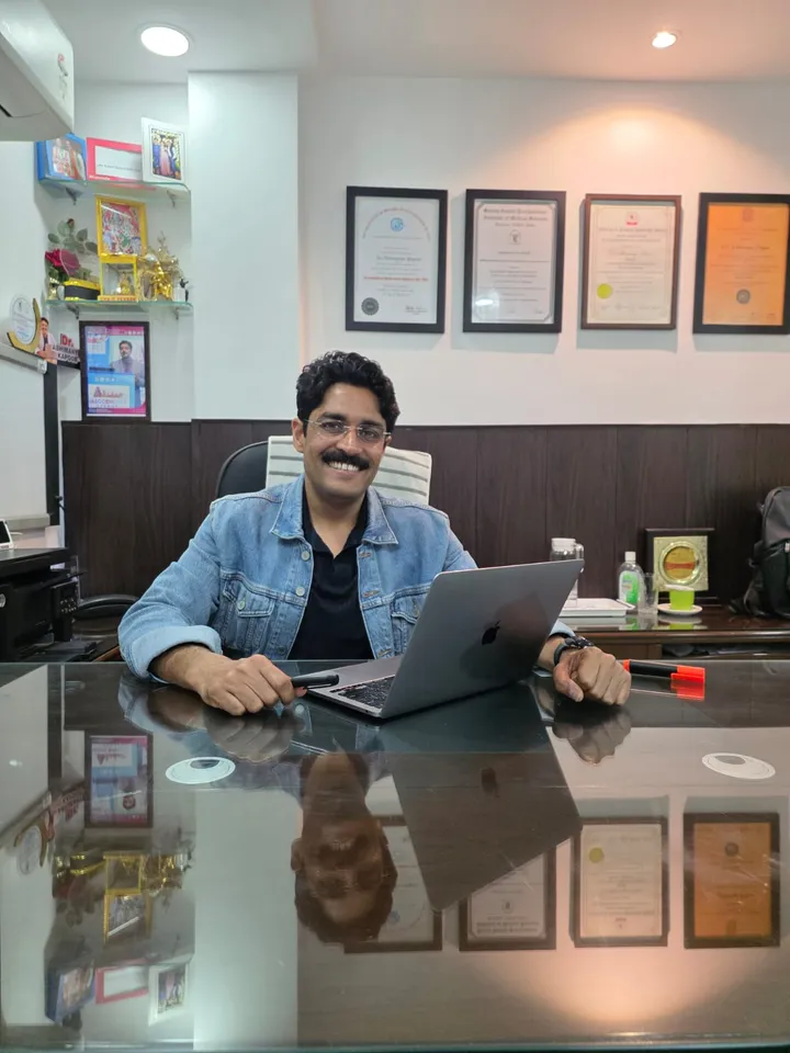 Dr. Kapoor at his desk in the consulting room
