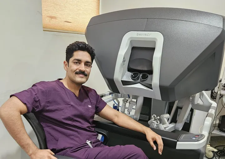 Dr. Kapoor beside the da Vinci robotic console