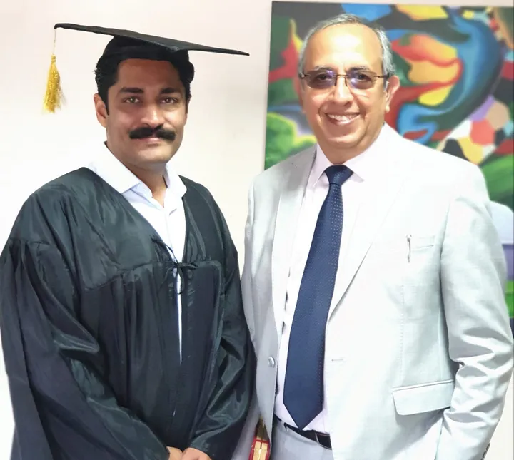 Dr. Kapoor in convocation gown with his mentor at a fellowship ceremony