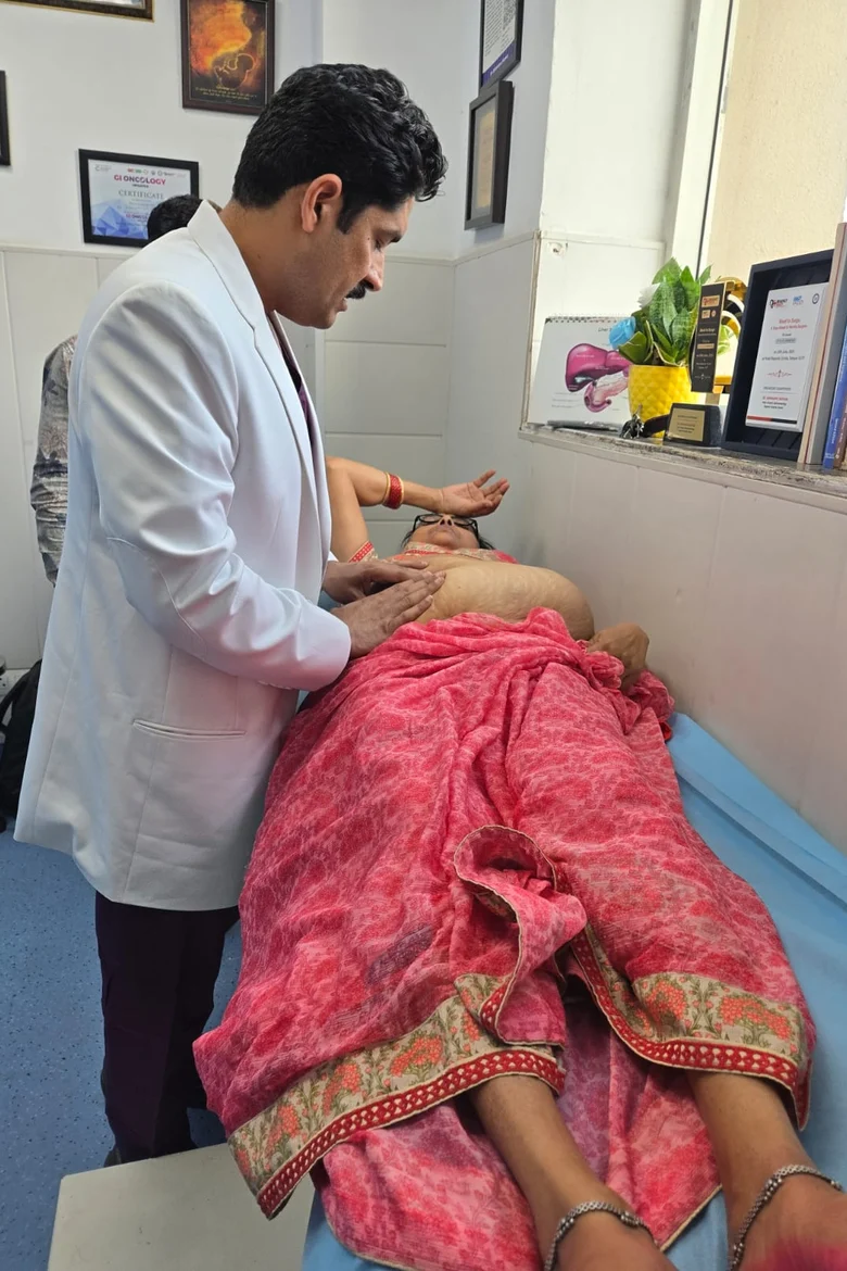 Dr. Abhimanyu Kapoor examining a patient's abdomen in the OPD