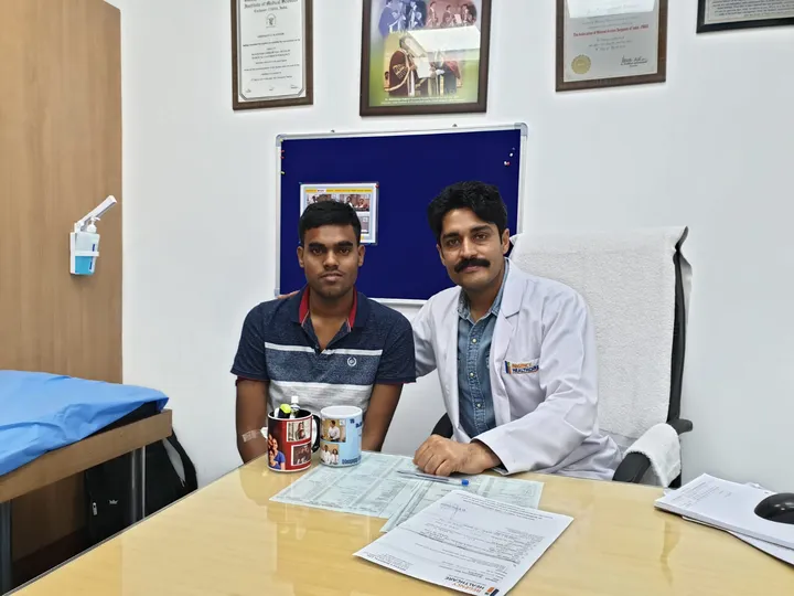 Dr. Kapoor consulting a young patient across his OPD desk