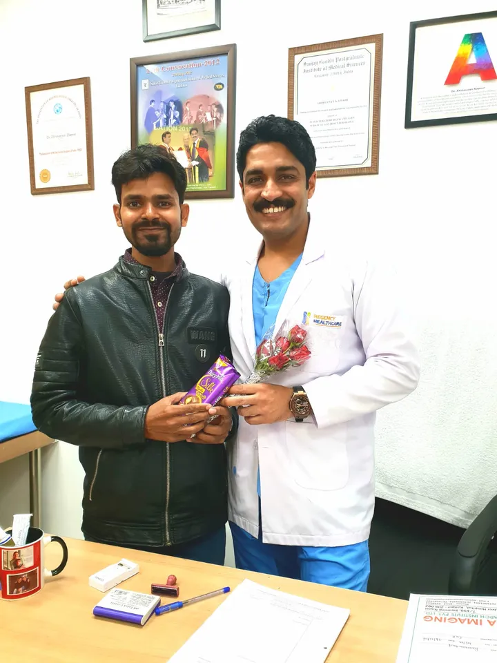 A grateful patient sharing sweets with Dr. Kapoor in the OPD