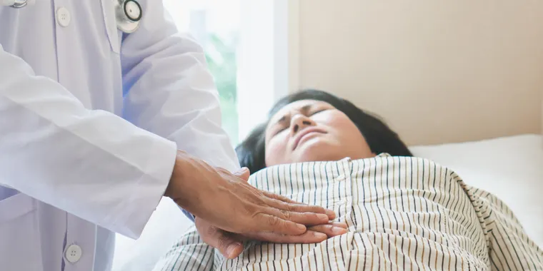 Doctor examining a patient's abdomen for a hernia