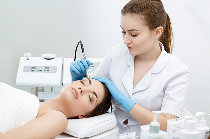 Skin Specialist performing treatment on face of a patient