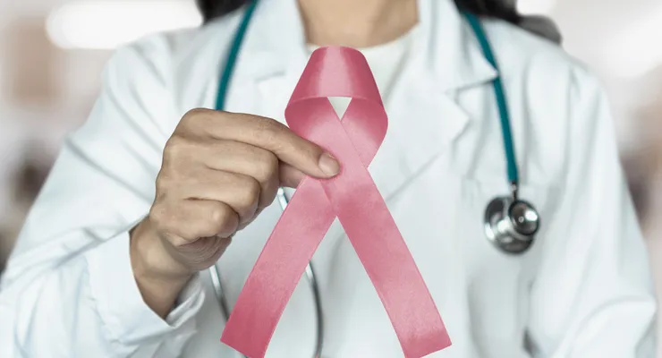 Doctor holding a pink ribbon for breast cancer care