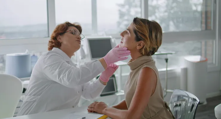 Doctor examining a patient’s jaw and salivary glands