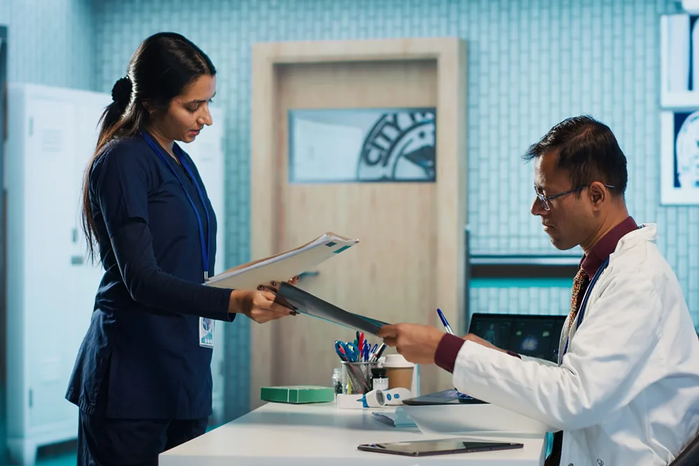 Two specialists reviewing a patient’s head and neck imaging together while planning treatment
