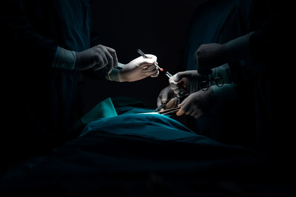 Surgical instruments being passed during an operation in a sterile theatre