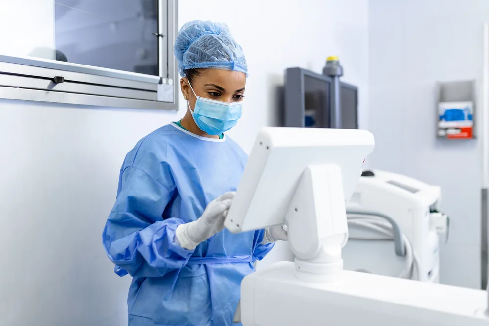 Surgeon at an image-guided surgical console in a modern operating theatre