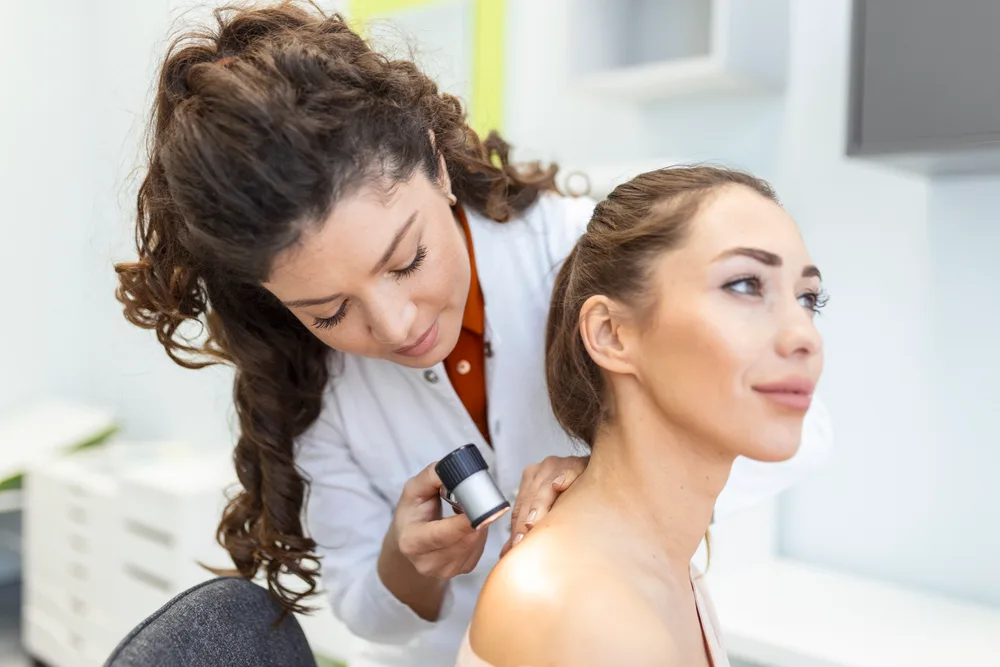 Specialist examining a skin lesion on a patient’s face