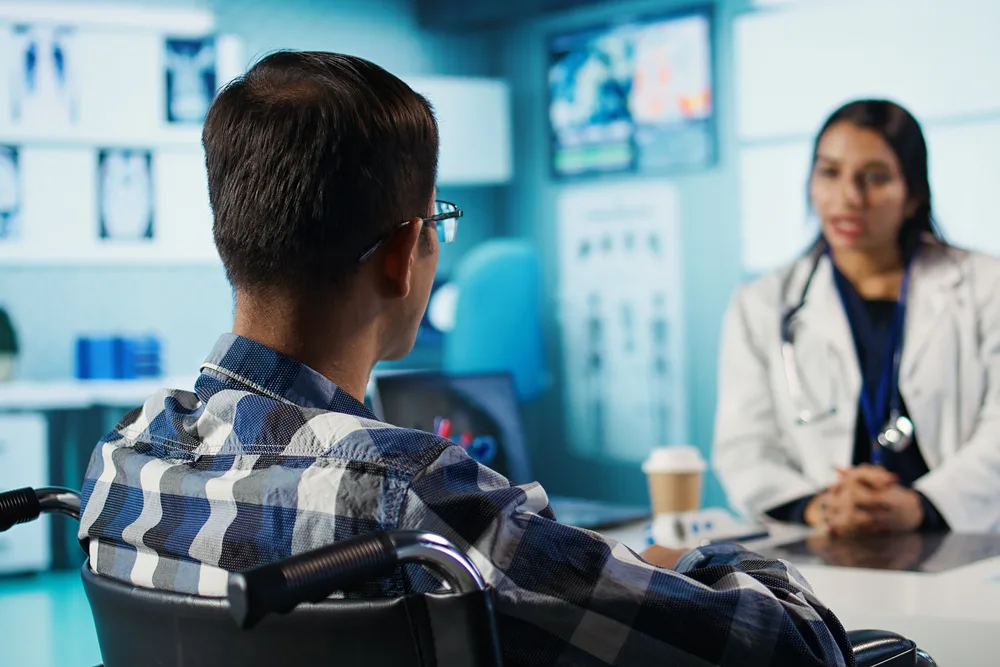 Specialist talking a patient through his treatment plan across a consulting room desk